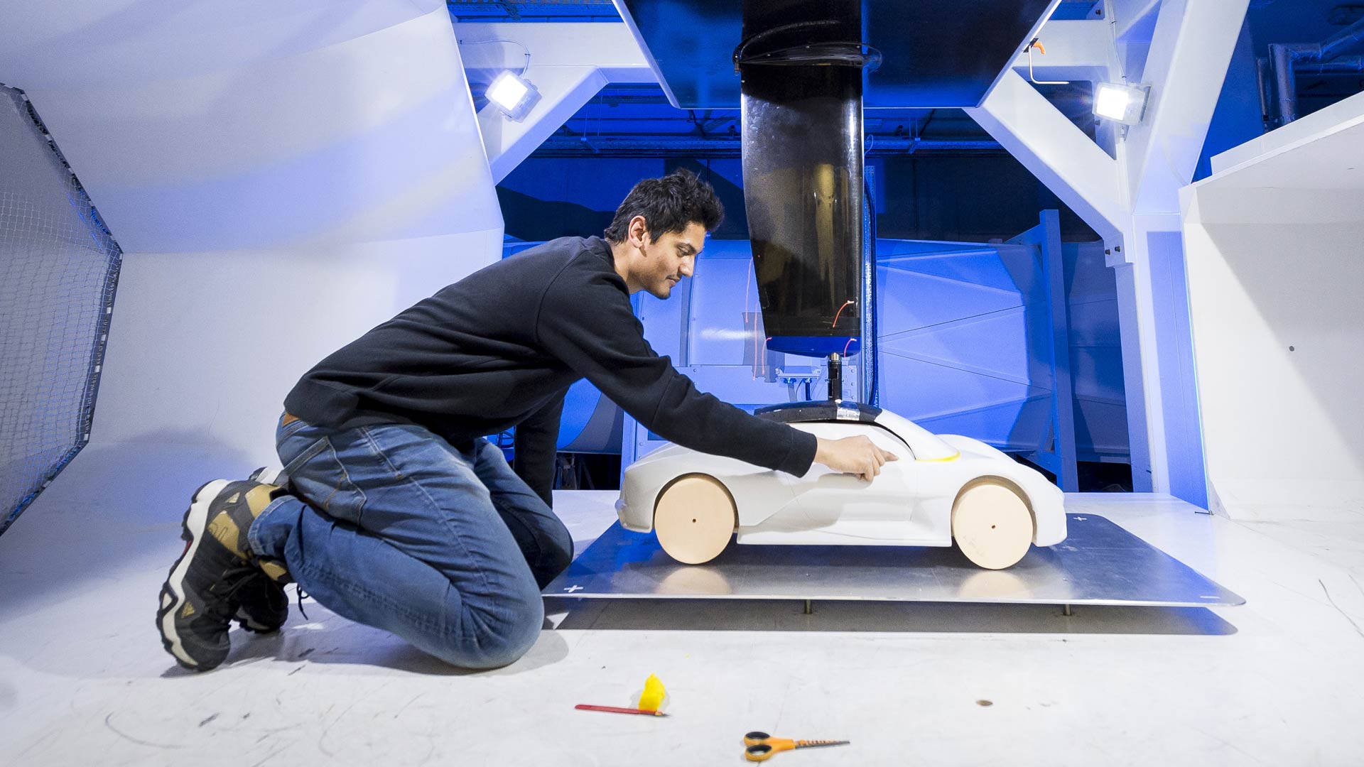 Student leaning over an automotive prototype model