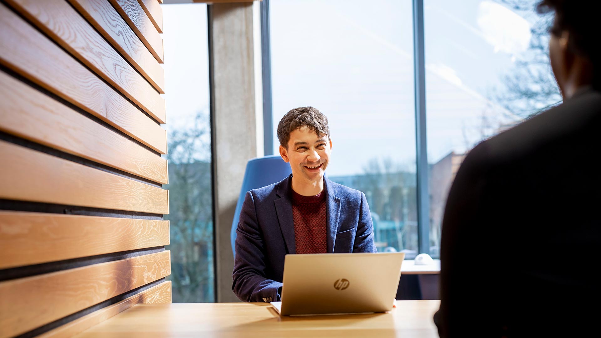 Man sat in front of laptop smiling 