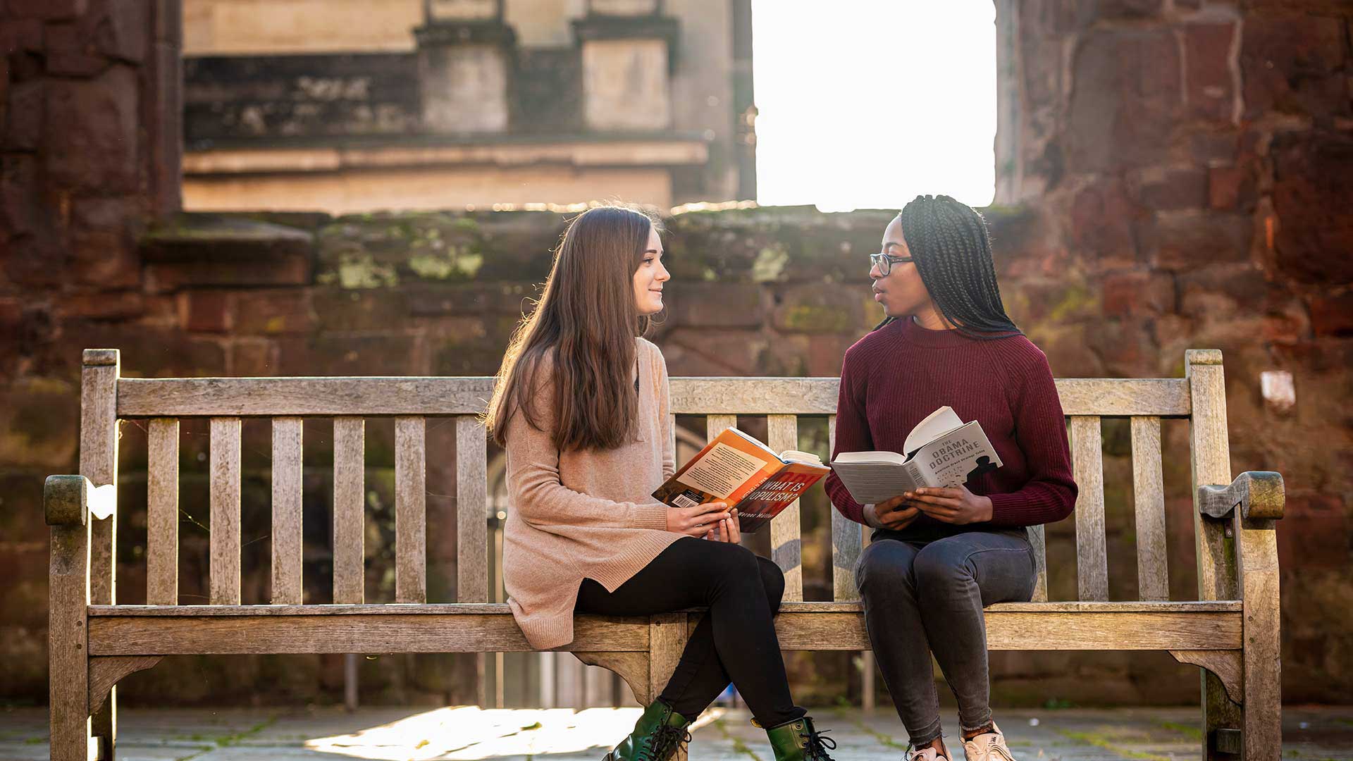 Two students sitting in the Coventry Cathedral ruins
