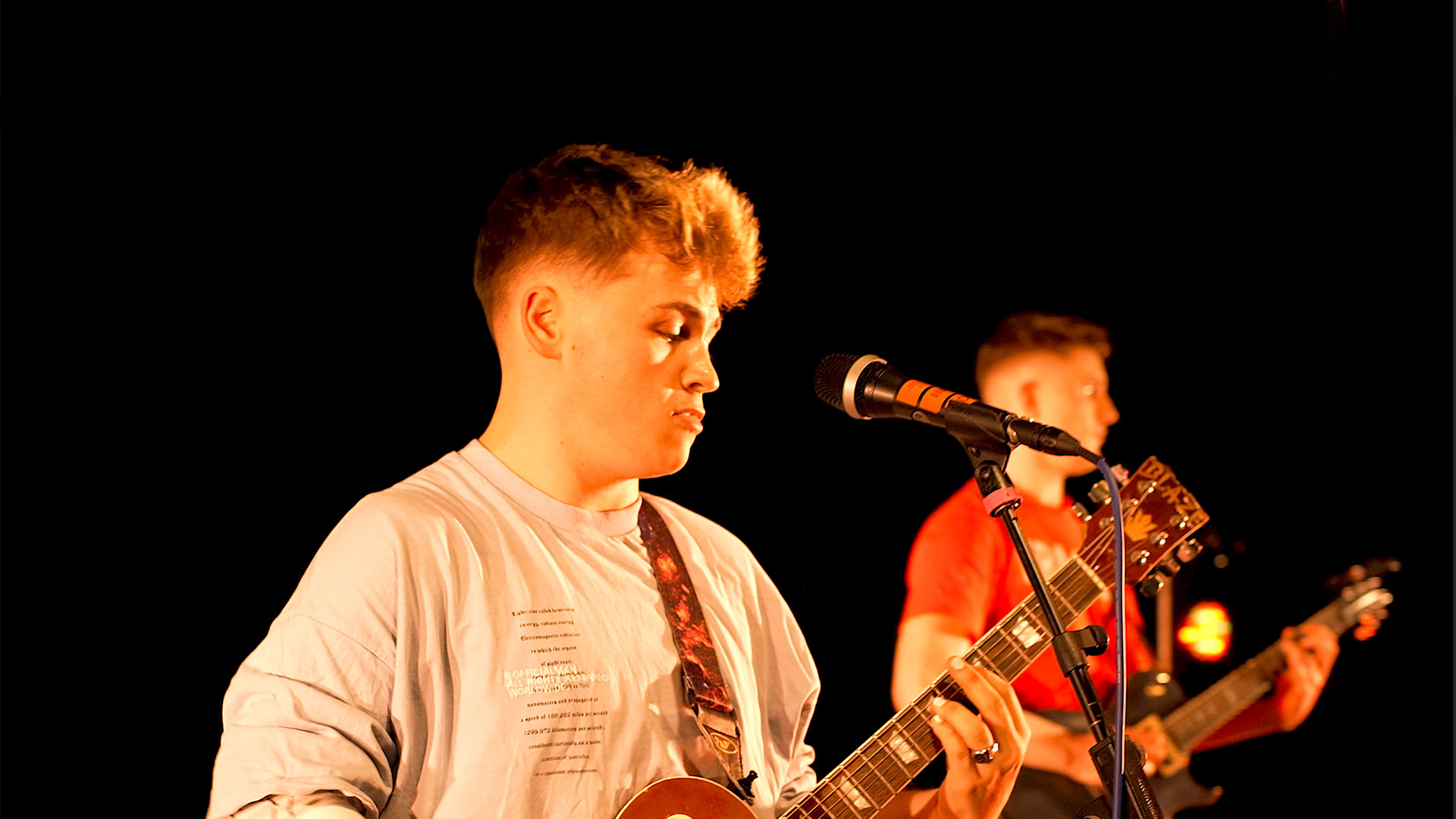 Two students playing guitar and singing