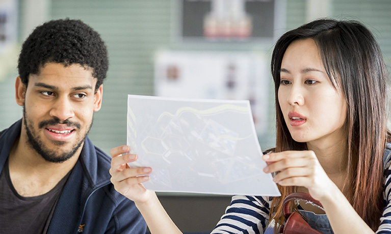 Two students looking at photographs they have printed
