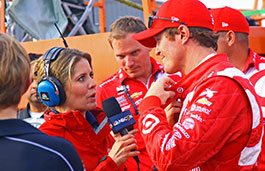 Female reporter interviewing a male race driver 