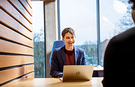 Man sat in front of laptop smiling 