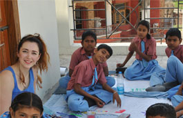 Adult female surrounded by a group of smiling kids