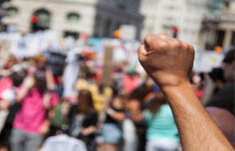 Close up of raised fist against blurred background of a crowd