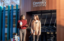 Two students talking outside a university building