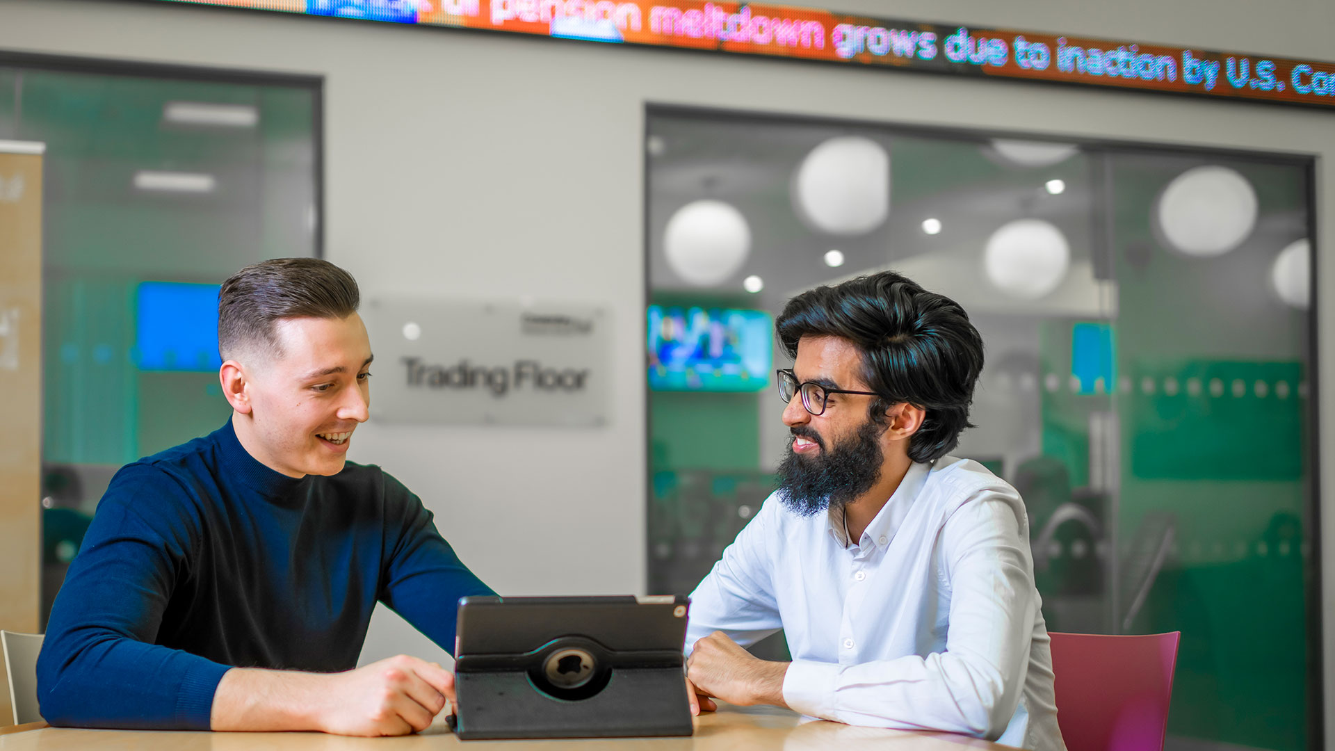 Students in a meeting room in conversation. 