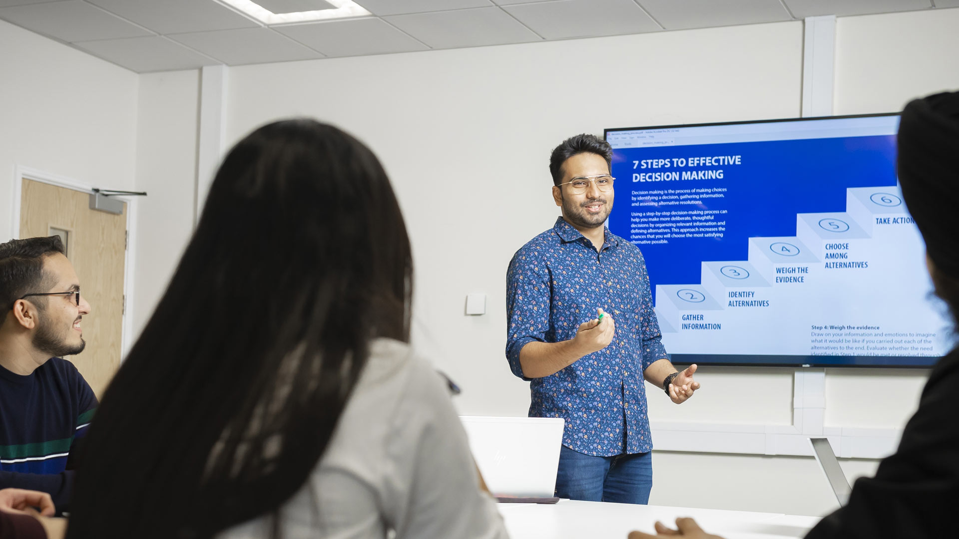 Student presenting a slide show in a boardroom