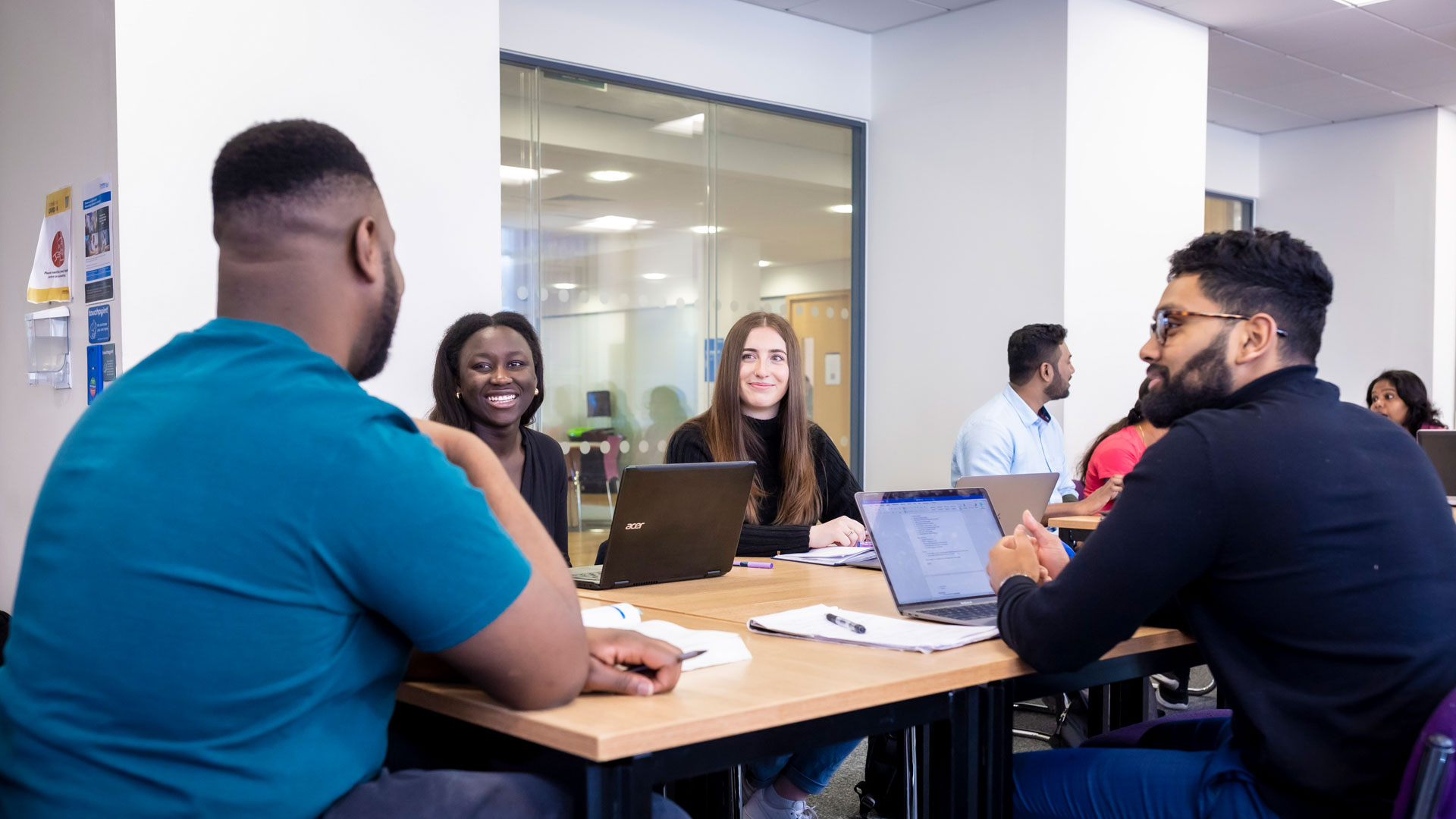 group of students around a table smiling and chatting