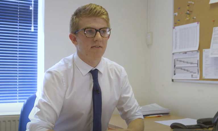 Student Caleb Mellen in a shirt and tie in an office