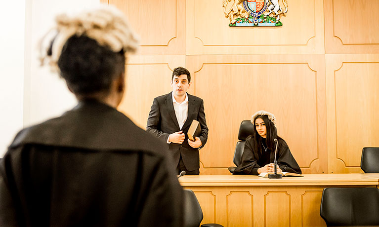 Group of students and a lecturer practicing in the Moot Room