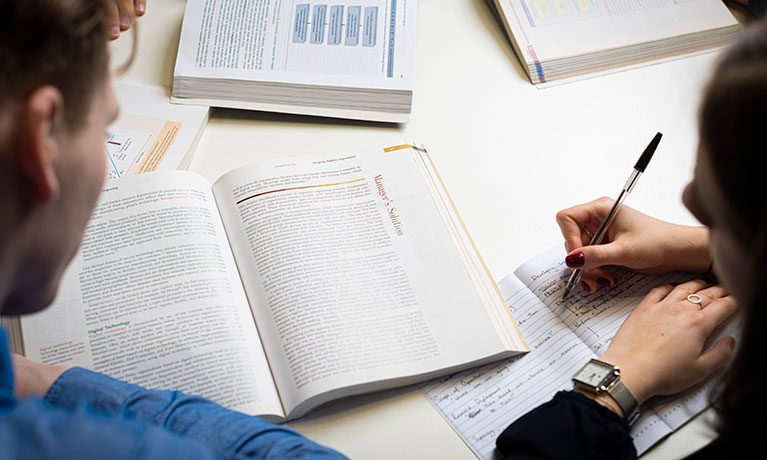 Two students studying from a book