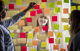 A student and tutor using sticky notes on a clear think board
