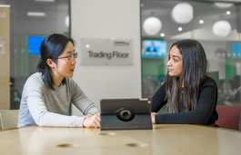 two females in a room looking at a tablet 