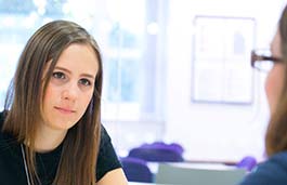 close up head shot of a young female student chatting to another female