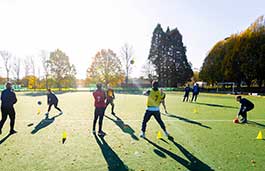 Students on a football pitch training 