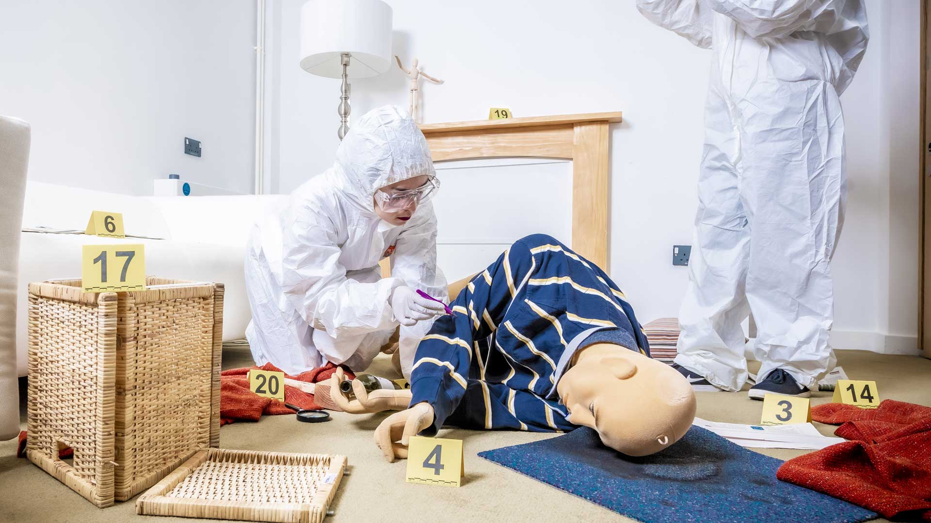 Students in forensic suits working on a simulated crime scene