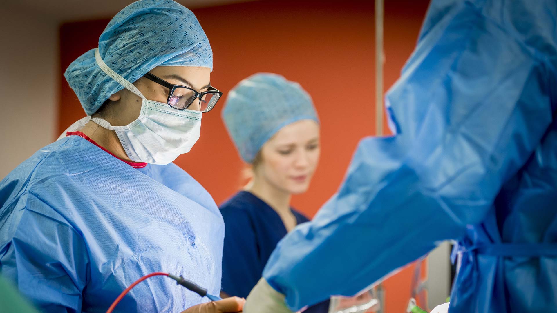 Students in scrubs in a mock operation scenario in the operating theatre