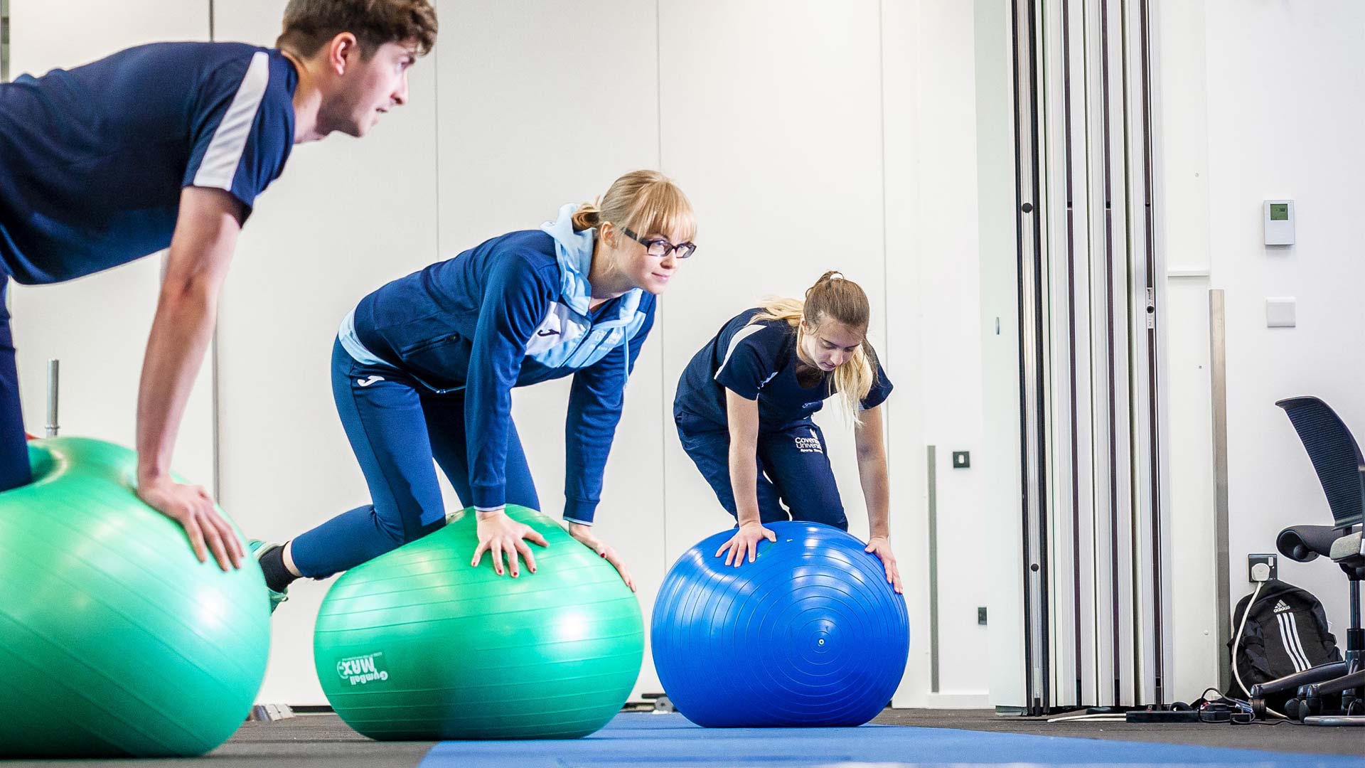 Three students using balance balls