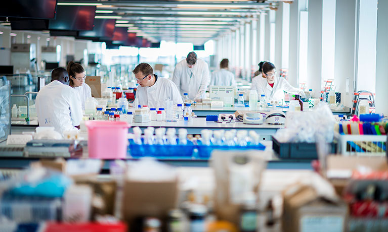 Inside of a laboratory filled with people wearing white coats