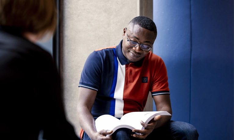 A student reading in the Alison Gingell science and health building.
