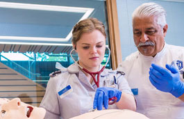 A tutor instructing a student using a manikin