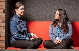 Two women sat on a sofa chatting