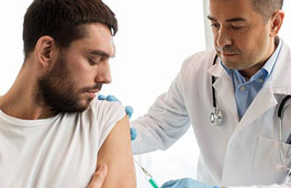 Doctor administering a vaccine to a male patient