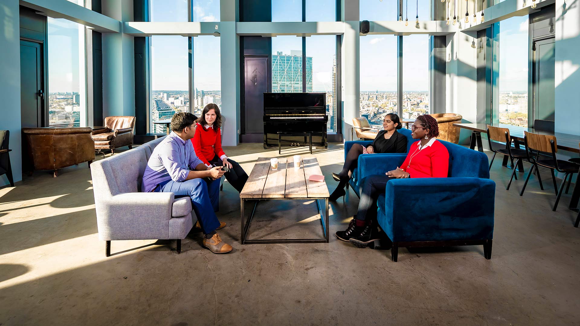 Four people sat in a breakout area in discussion