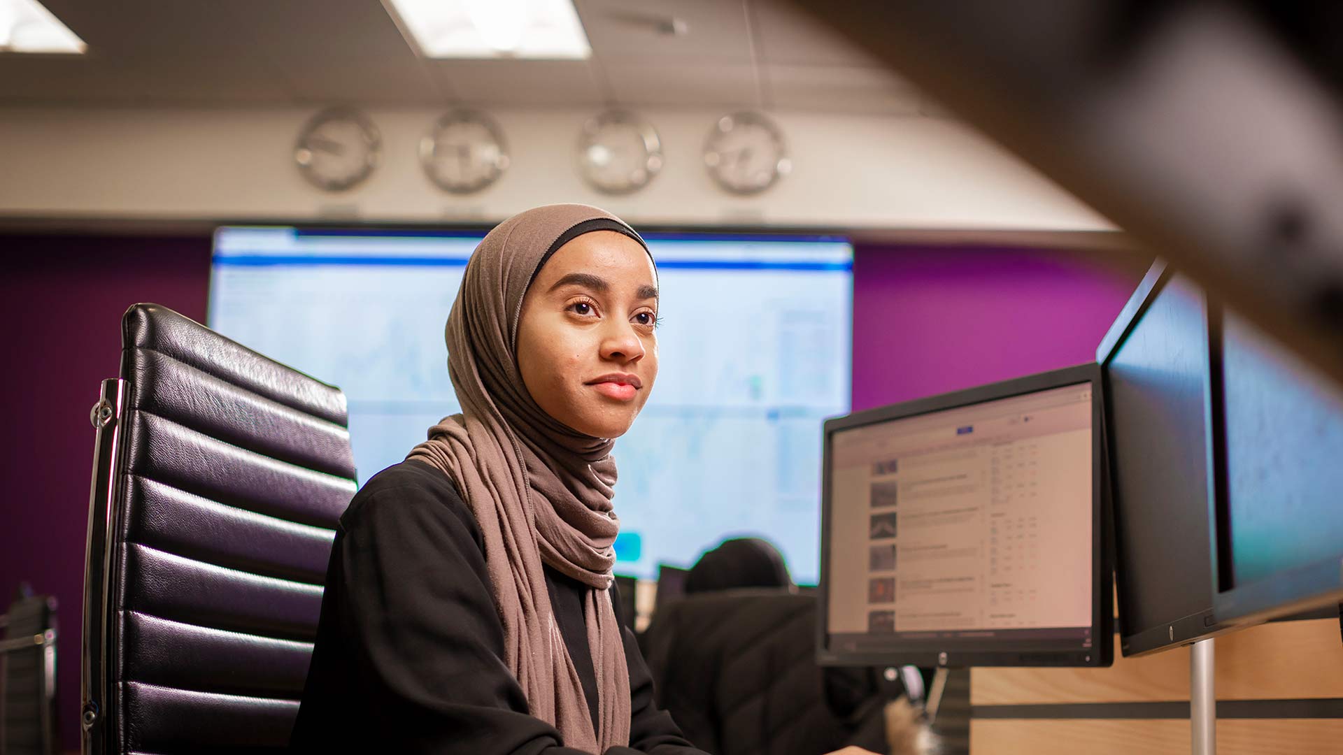 Student wearing a headscarf working at dual screen desktop