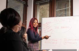 Student pointing at a white board displaying recruitment process 
