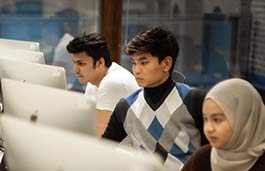 3 students working intently staring at monitors