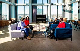 Four people sat in a breakout area in discussion