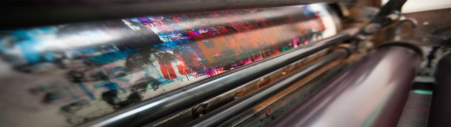 Close up a printing press with paint smudges on a drum 