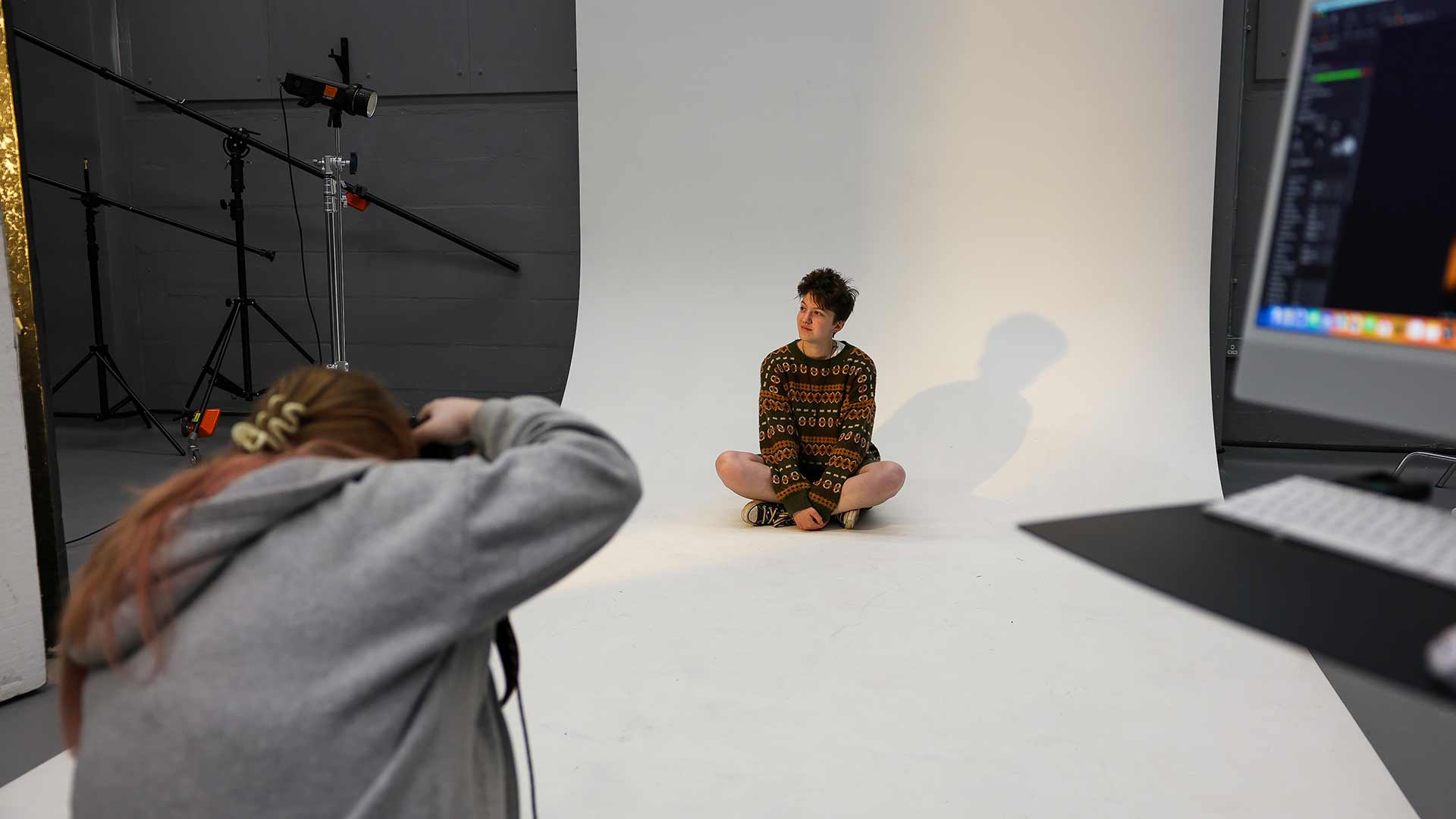 Photography studio with a white background, coloured lights and equipment around
