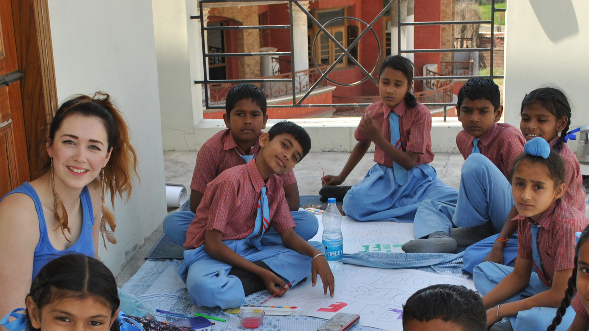 Adult female surrounded by a group of smiling kids