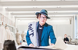 Fashion student wearing a blue hat colourful jacket. 