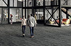 People walking across the floor of a large open plan building