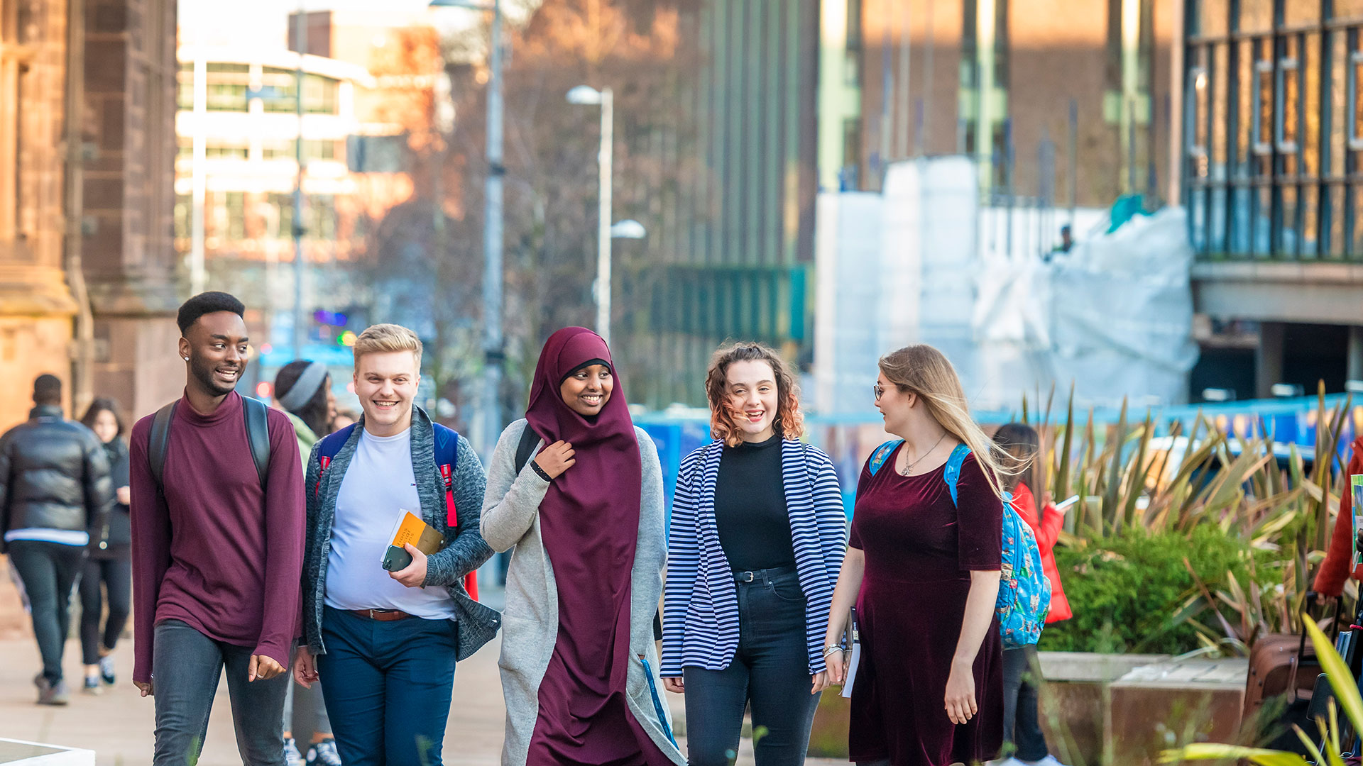 smiling students walking across campus