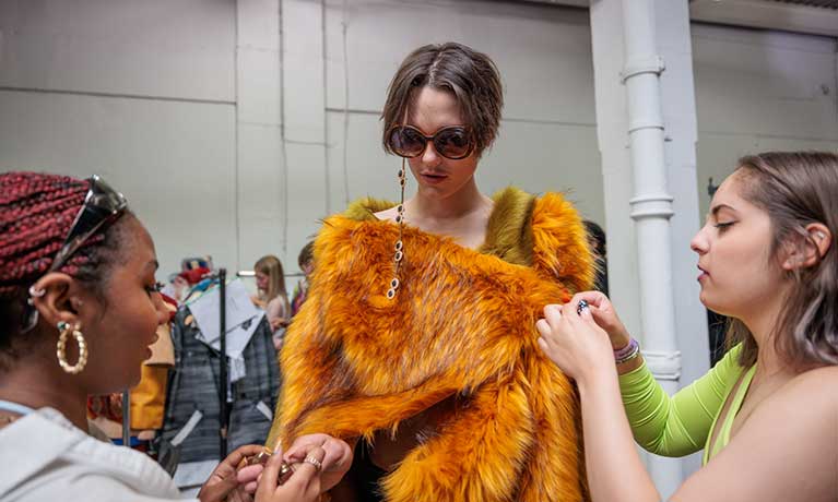 Rebecca Ryder Caddy dressing a model at a fashion show