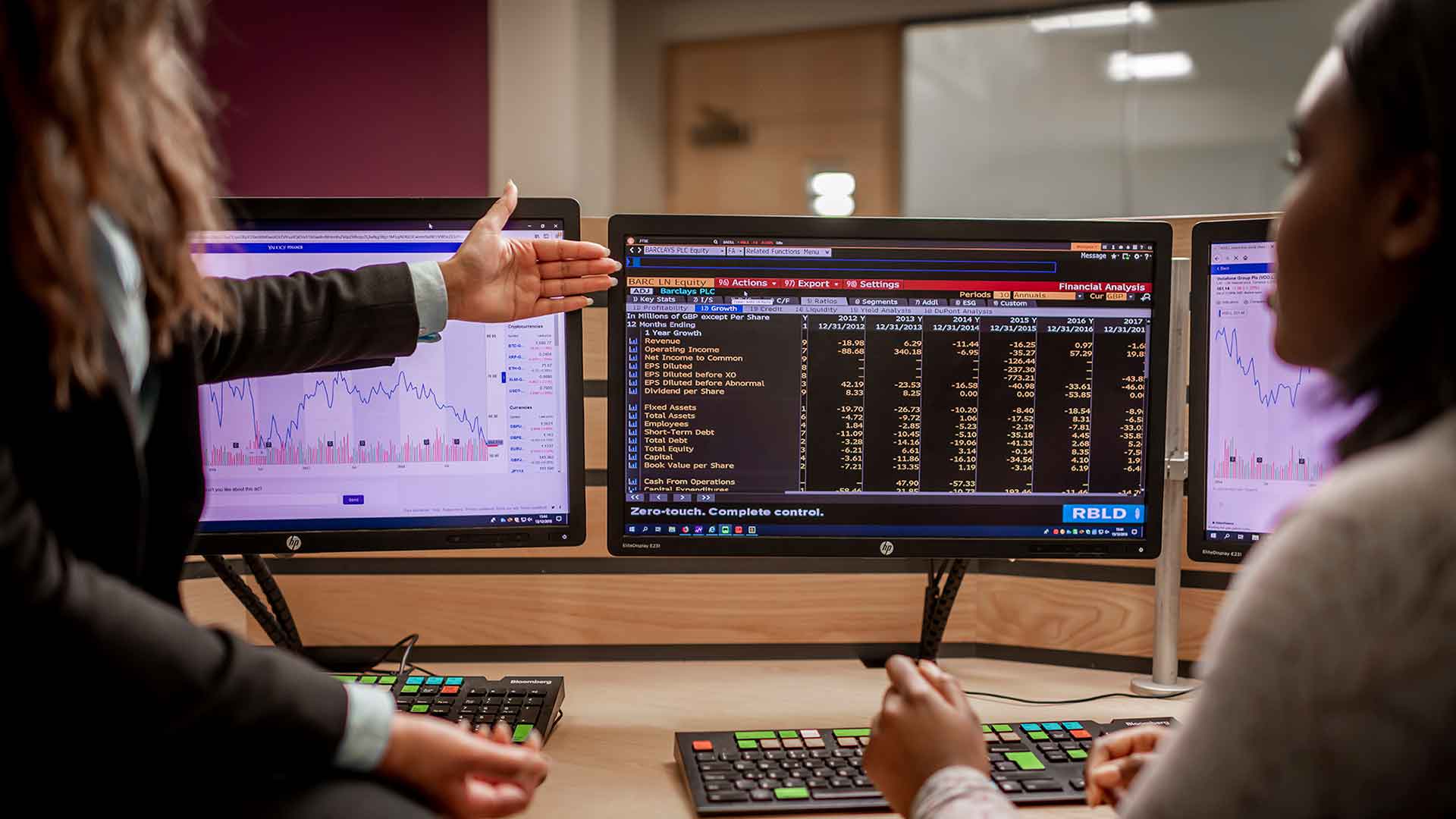 A couple of students working at a computer screen with accountancy related software