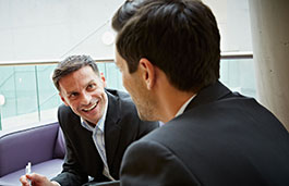 Two men wearing suits having a serious conversation.