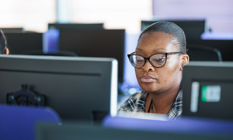 A woman sat at a computer in the IT suite