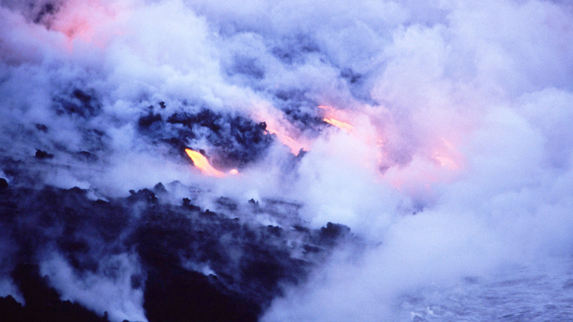 Close up of an erupting volcano with molten lava and smoke