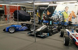 3 formula cars with Coventry university branding on display