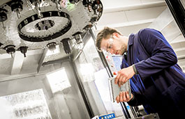 Man working on a big drill wearing a blue overall