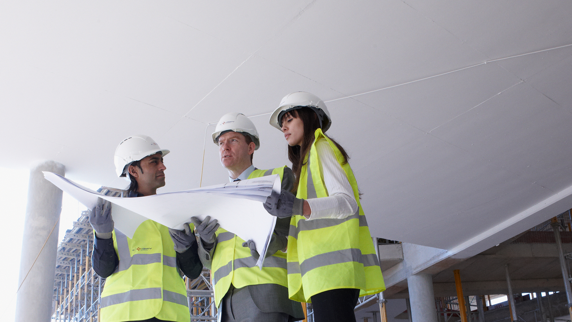 three people in high vis vests reading a report