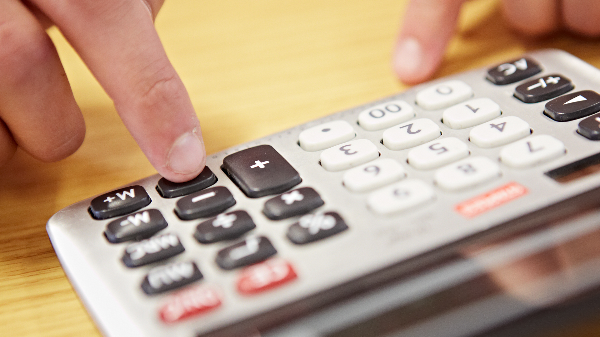 Close up of a person using a calculator.