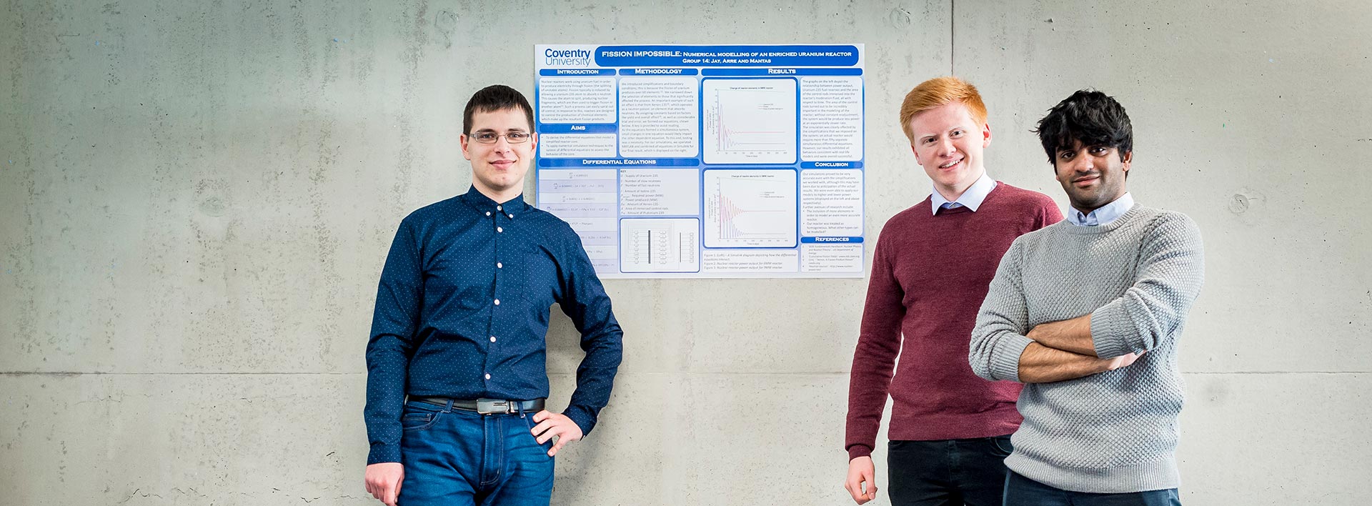 Three students standing in front of a poster