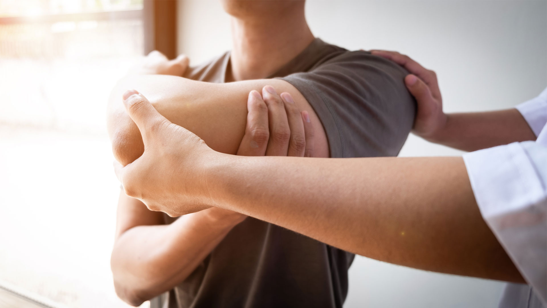 A physiotherapist treating an injured rotator cuff with a stretching exercise